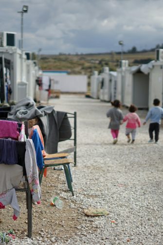 Children walking in a Syrian refugee camp in the outskirts of Athens
