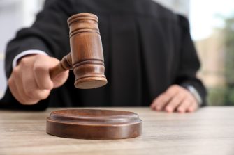 Judge with gavel at wooden table