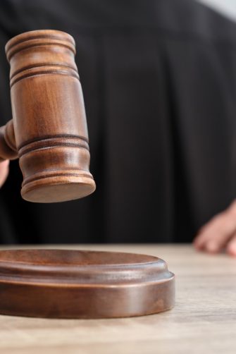 Judge with gavel at wooden table