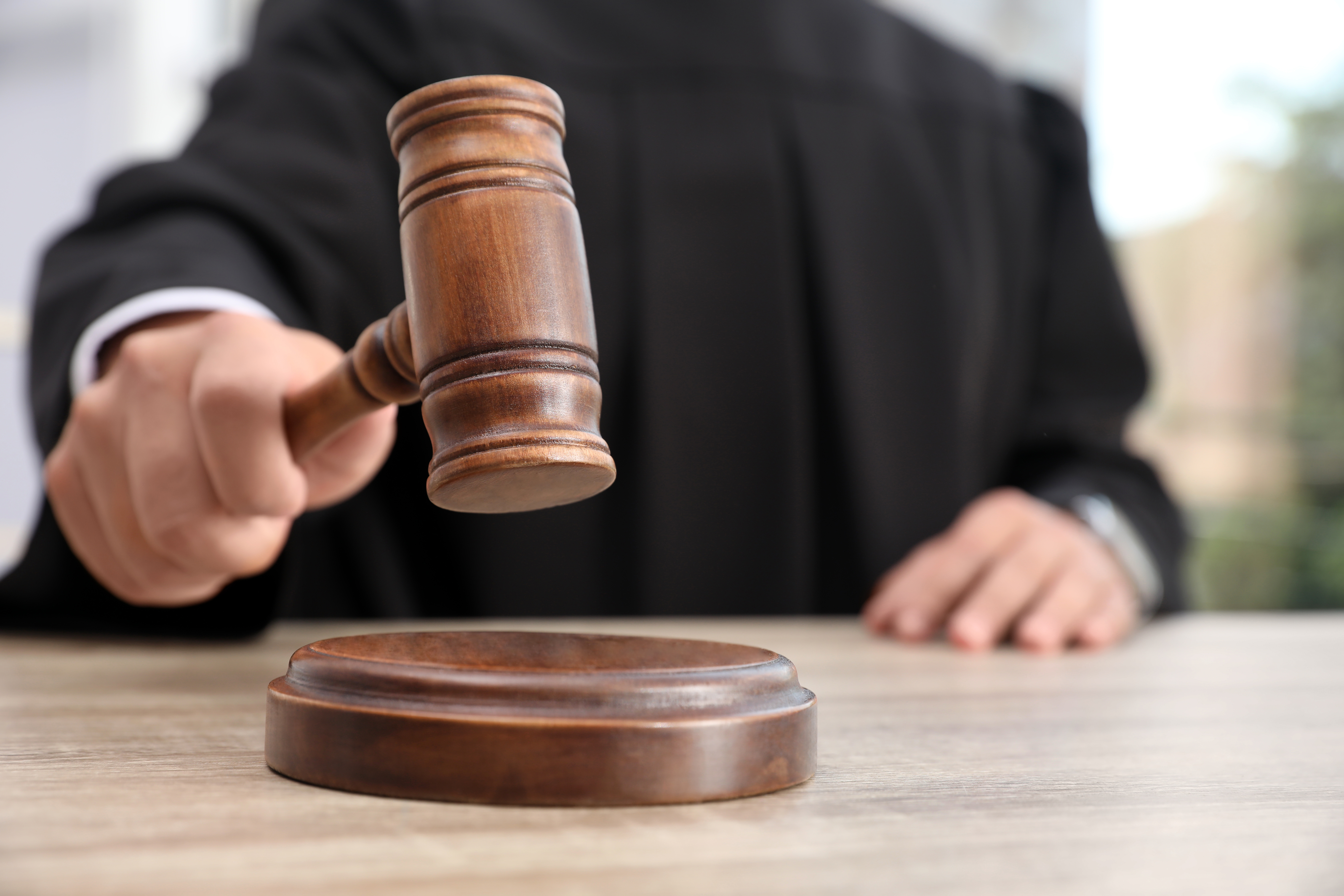 Judge with gavel at wooden table