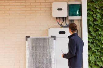 Back view of unrecognizable young man technician installing a solar system for renewable energy with solar panel