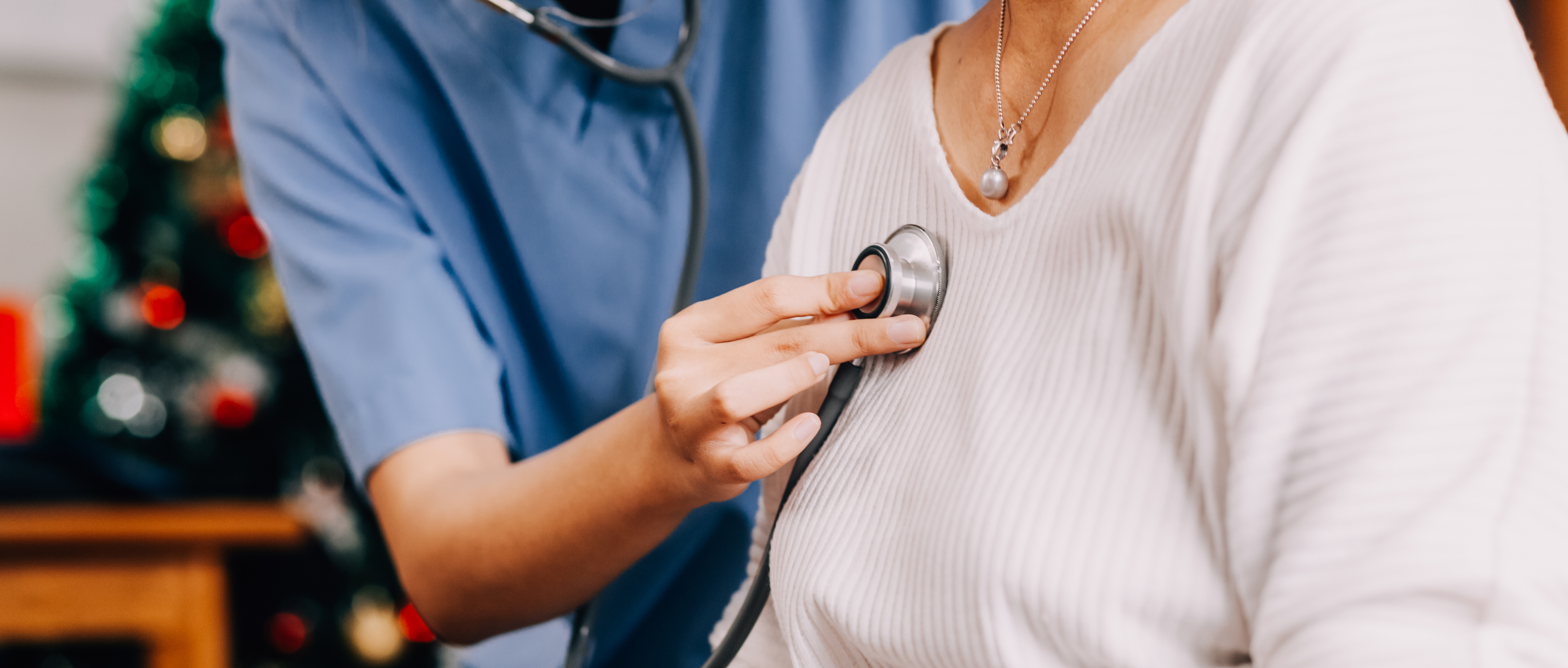 Lady coming to clinic for heart and lungs checkup, male doctor using stethoscope, listening to female patient's breath or heartbeat, sitting in clinic office