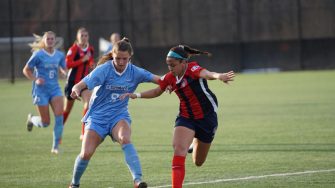 Two girls playing soccer