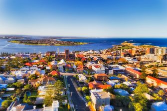 City of Newcastle in Australia north from Sydney - Hunter river mouth to Pacific ocean. CBD of industrial hub and sea port with local streets and houses around the Cathedral of Newcastle.