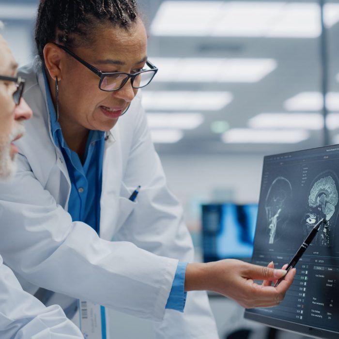 Medical Hospital: Neurologist and Neurosurgeon Talk, Use Computer, Analyse Patient MRI Scan, Diagnose Brain. Health Clinic Lab: Two Professional Physicians Look at Functoning CT Scan Find Treatment