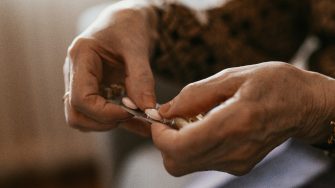 Close up of senior woman's hands taking pills and medications