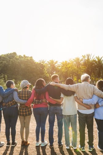 Group of multigenerational people hugging each others - Support, multiracial and diversity concept - Main focus on senior man with white hairs