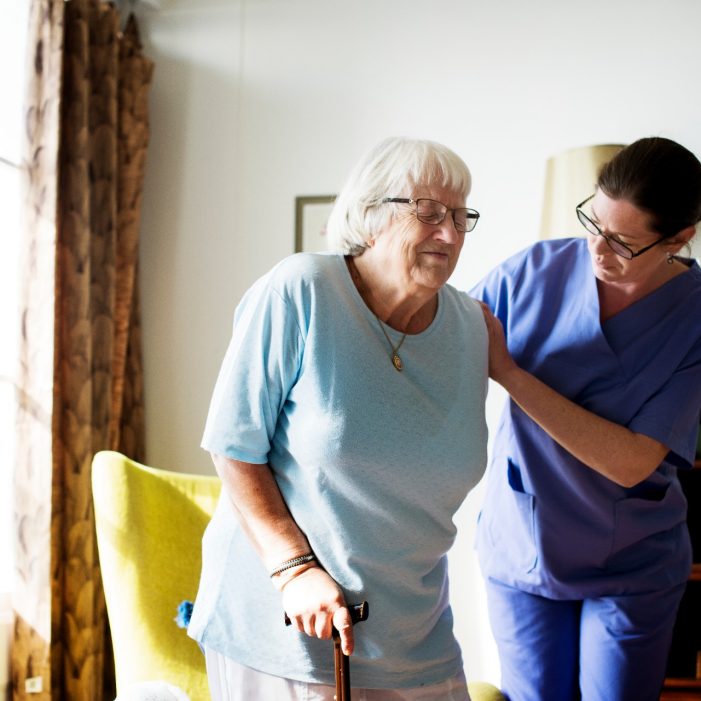 Nurse helping senior woman to stand
