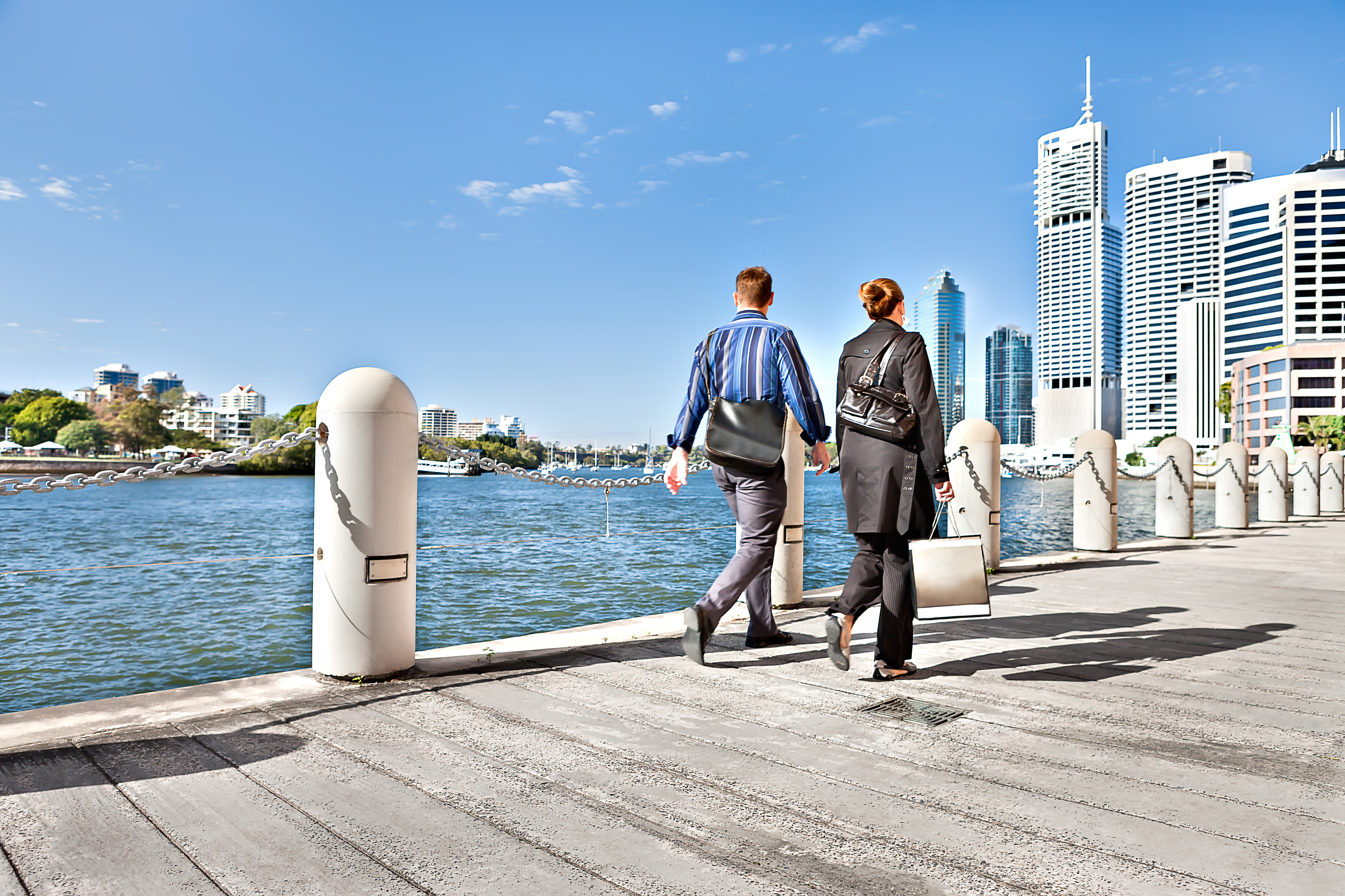 Two people with the business suit walking on waterside street that belongs to Brisbane City, Queensland, Australia.