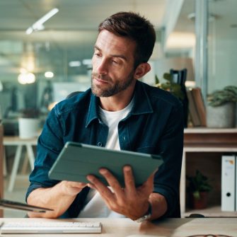 Tablet, reading and laptop with business man in office for planning, ui designer and app review. Developer solutions, client feedback and research with person in agency for project idea and startup.