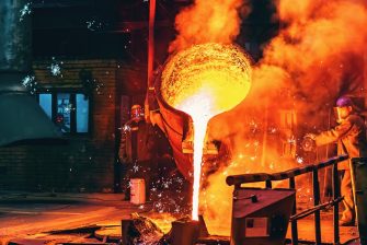 Liquid iron molten metal pouring at an industrial metallurgical factory.