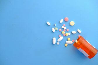 Bottle of pills spilling onto a blue background stock image medicine medication