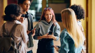 Teenagers laughing in a group at high school