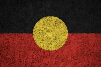 Australian aboriginal flag attached to baby stroller at indigenous community ritual smoking ceremony rite