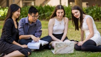 Students studying in a group on the grass