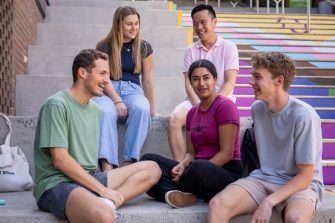 A group of students sitting on the Basser Rainbow Steps 