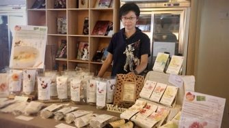 Photo of Peggie Zih showcasing her natural health products, featured in a UNSW alumni news article highlighting her career change.
