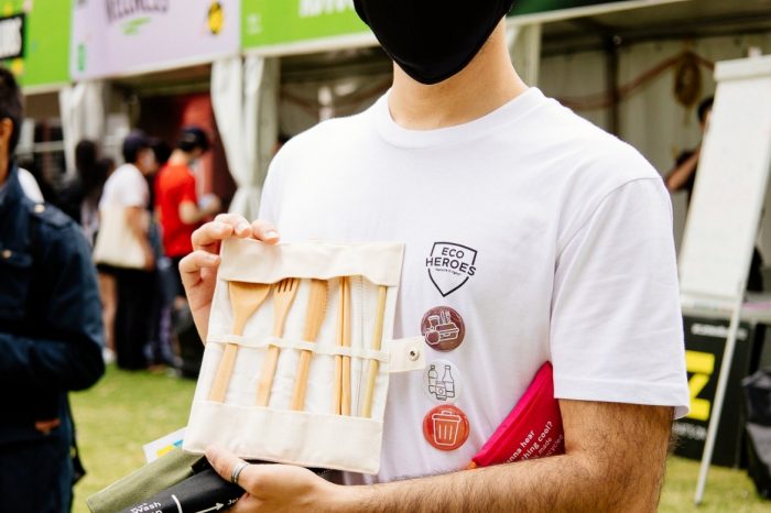 Student volunteer holding up UNSW Plastic Free reusable cutlery