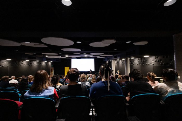 Audience members in EG02 watching the Creative Conversations panel members discuss developments in Ai