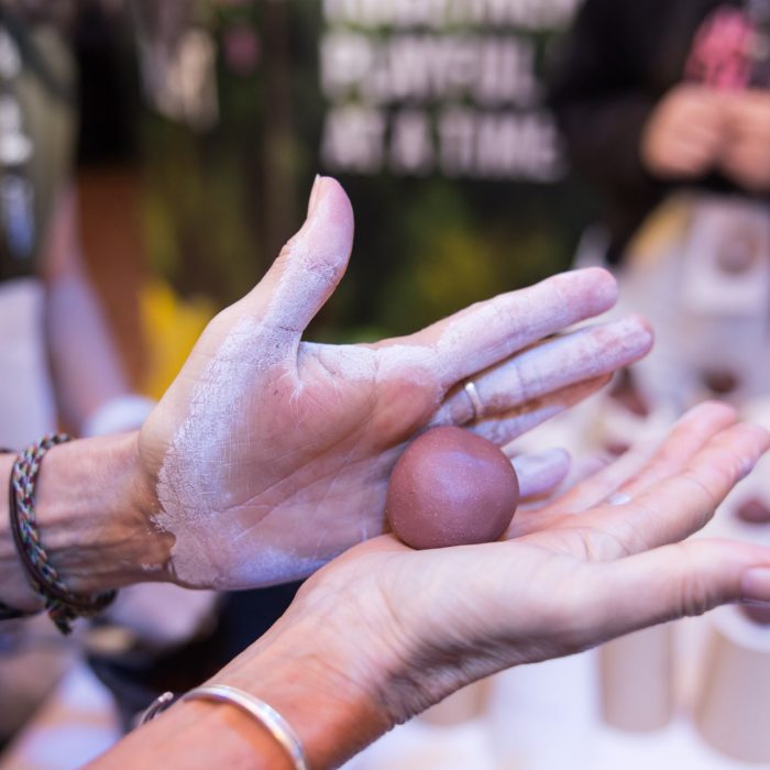 A guest creating a 'seed bomb' with the Daily Delight Disrupt project team