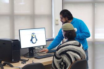 Two people looking at a computer monitor