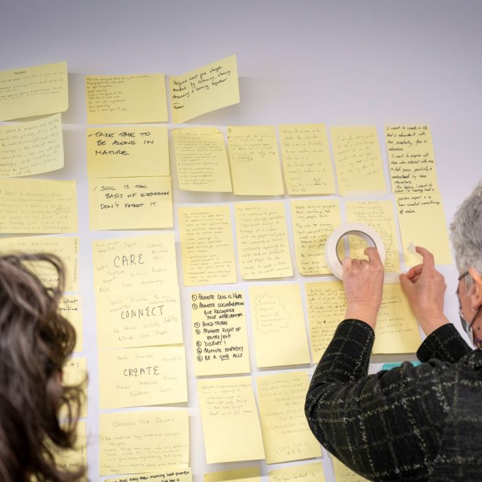 Person placing sticky note on display board