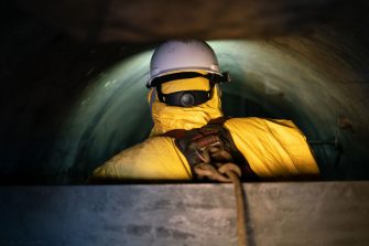 Photo of a worker taking photographs of internal pressure tanks in a confined space