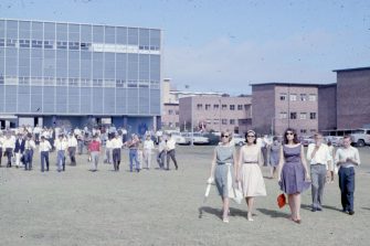 archive image of staff and students walking on campus grounds