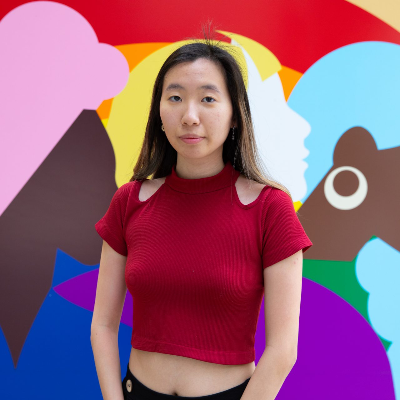 Winnie stands in front of a colourful mural