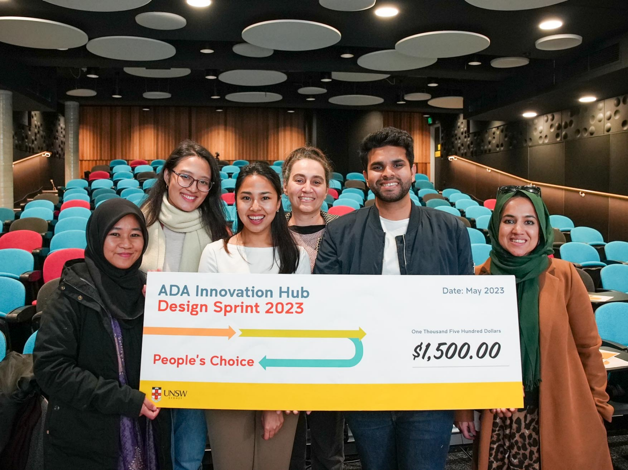 People's choice award winning team from ADA Innovation Hub Design Sprint 2023 hold giant novelty cheque