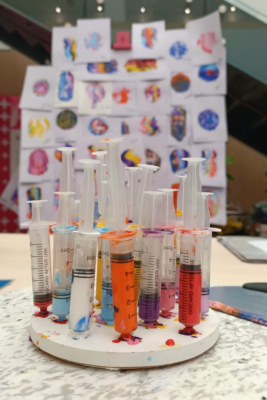 Multiple syringes filled with colourful paint