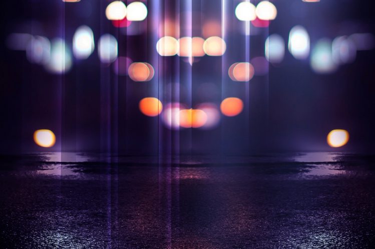 Reflection on the wet asphalt, the lights of the night city. Dark background with abstract bokeh, rays of light.