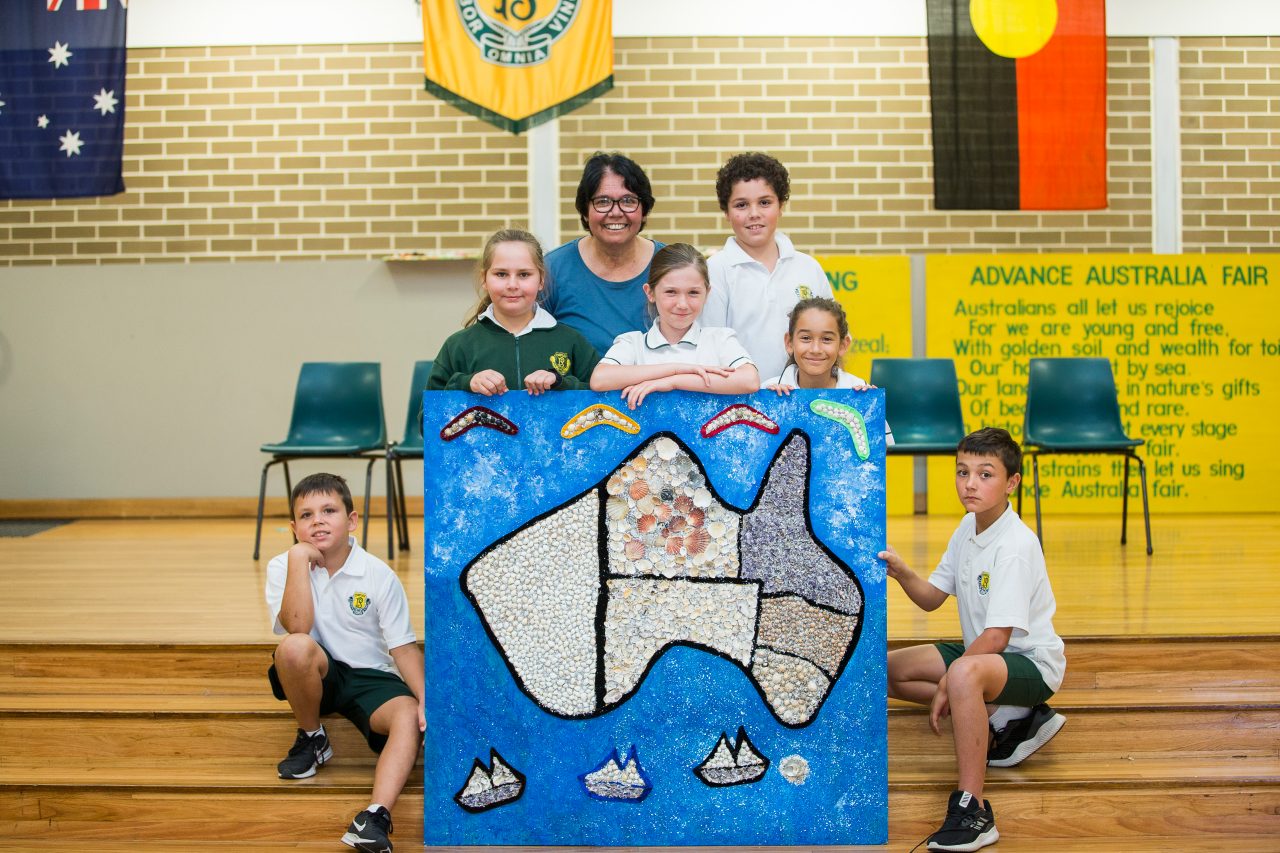 children and school boys with school girls with Aunty Maxine displaying one artwork