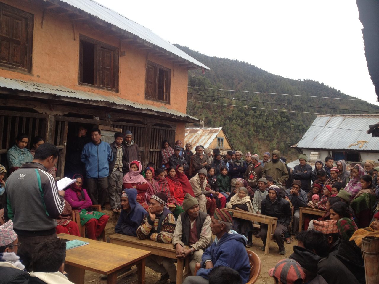 Group of people gathered in village street in Nepal for meeting with researchers