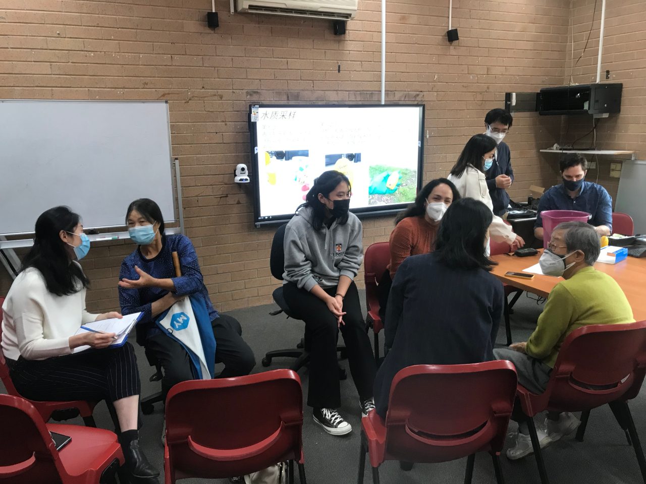 UNSW students sitting on chairs in a room collaborating 