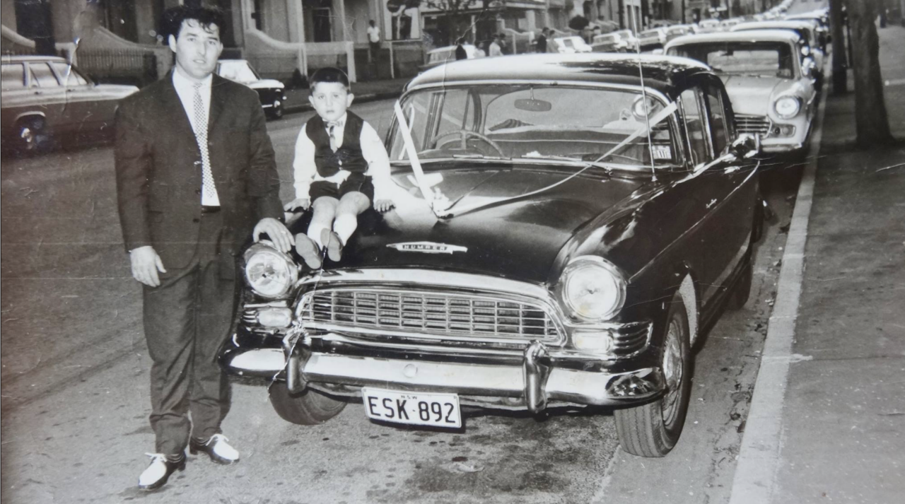 An image of a guy and a boy dressed up  next to a 1960s Humber 