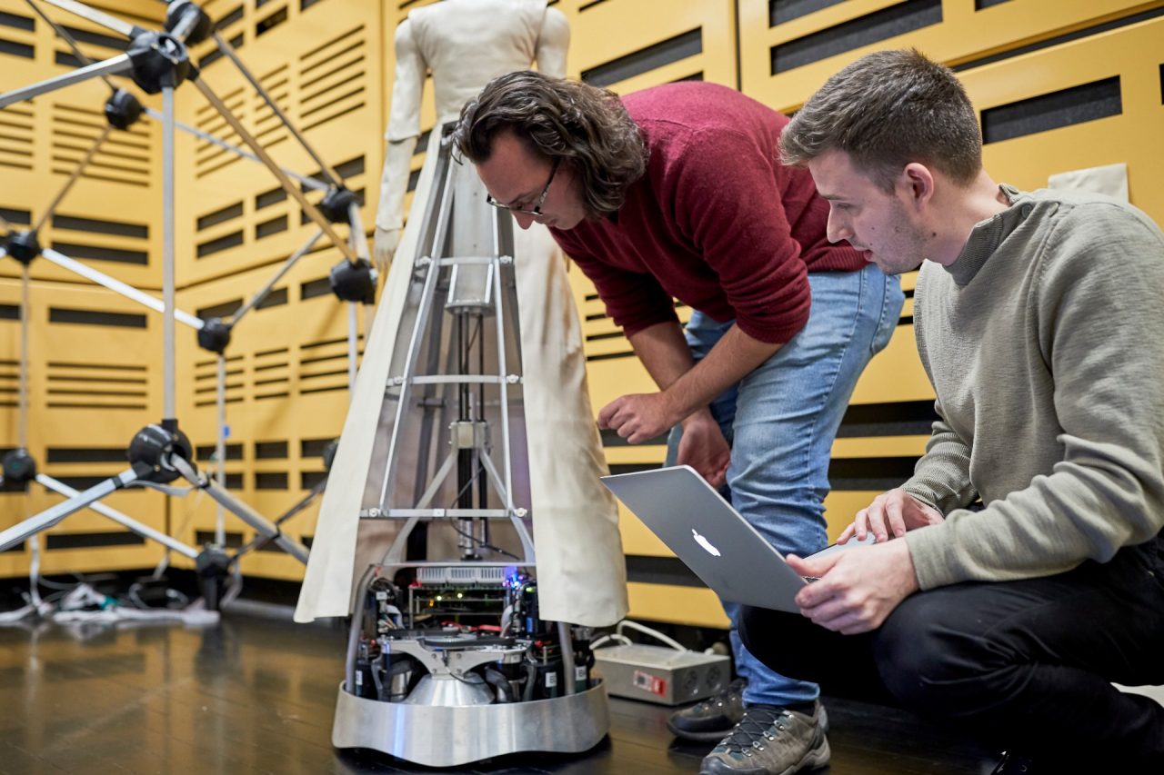 Researchers assembling and programing a robot