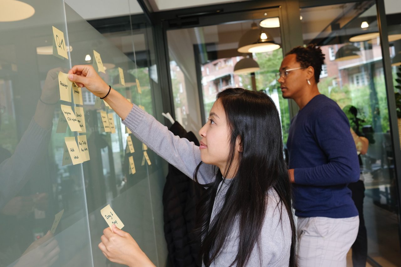 woman in grey shirt using post it notes