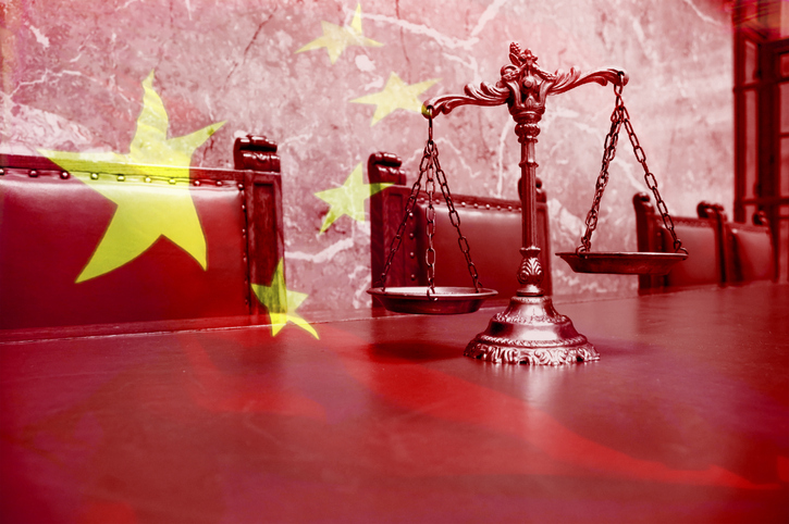 Decorative Scales of Justice on the red table with Chinese flag
