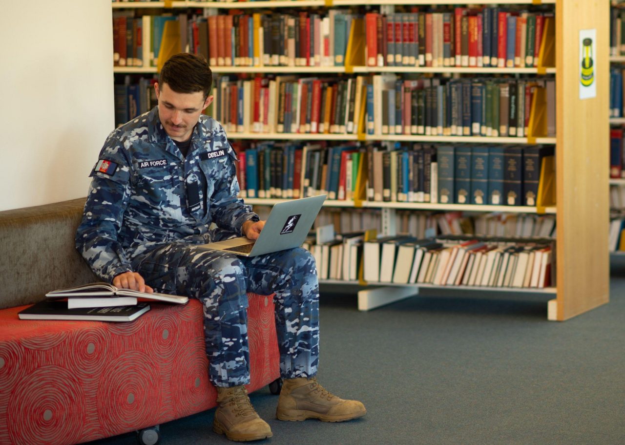 Man in camouflage gear sitting in the library