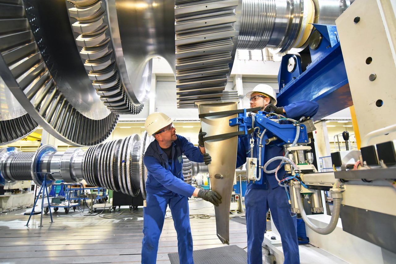 Engineers working in a factory wearing protective suits and gear