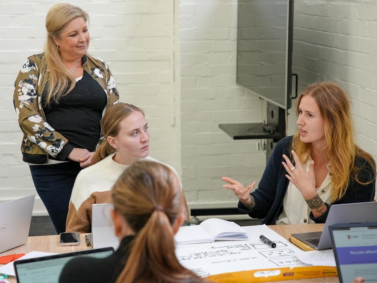 Team of students working together at a table during ADA Innovation Hub Design Sprint 2023