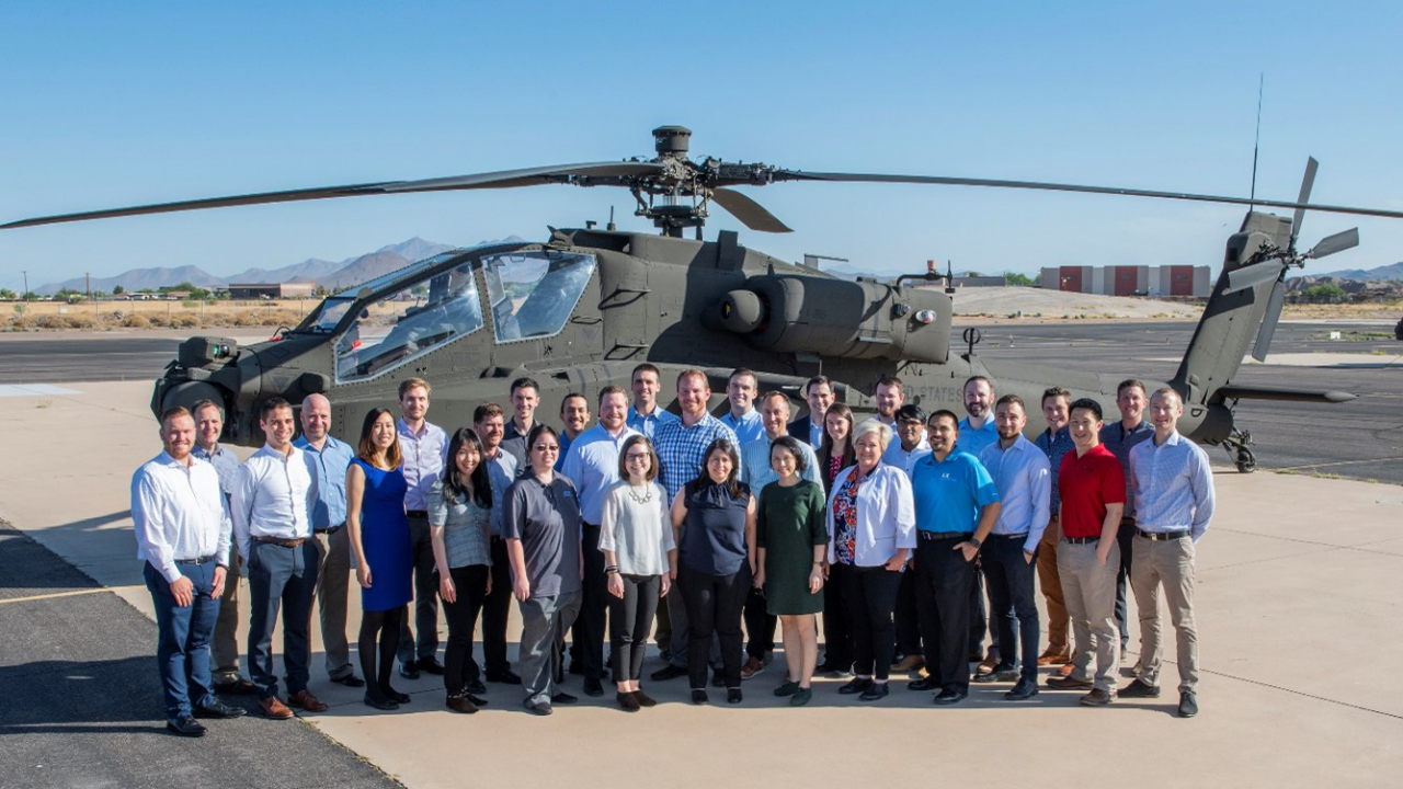 Max Osborne work group photo in front of helicopter