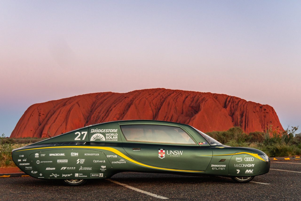 Sunswift car next to Uluru