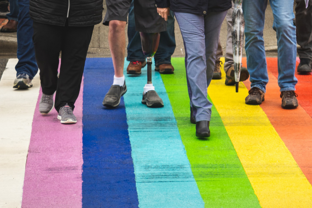 People walking across a rainbow crossing