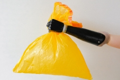 A prosthetic arm holds a yellow plastic bag