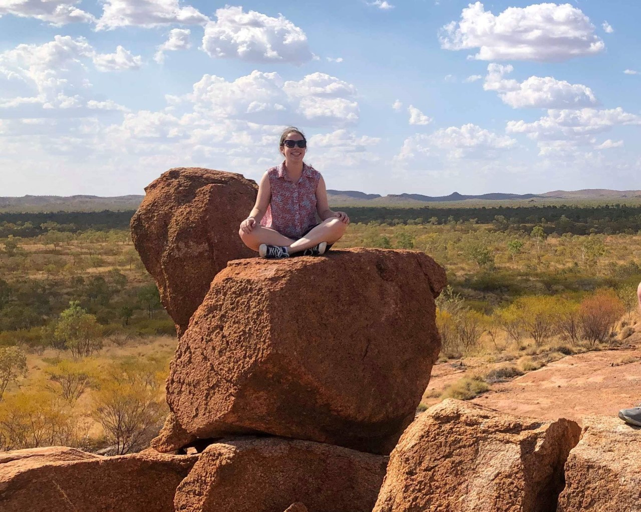 Lucy Barrie sitting ontop of a large rock in regional Australia