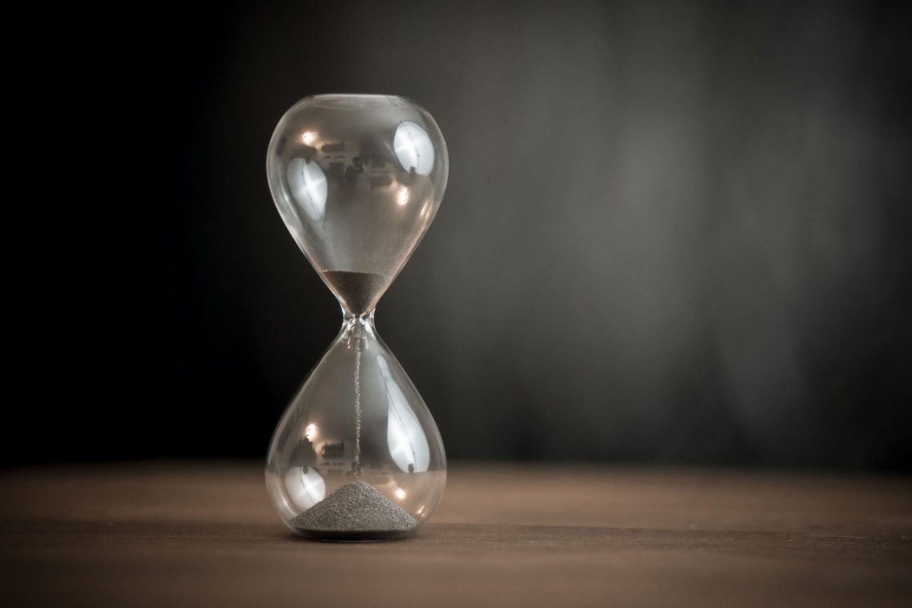 Stock image of hourglass on wooden background