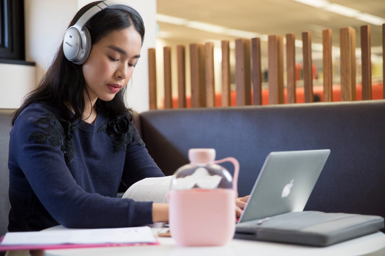 Student studying with headphones and laptop