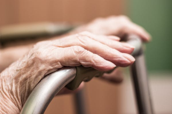 Elderly woman's hands on a walking frame